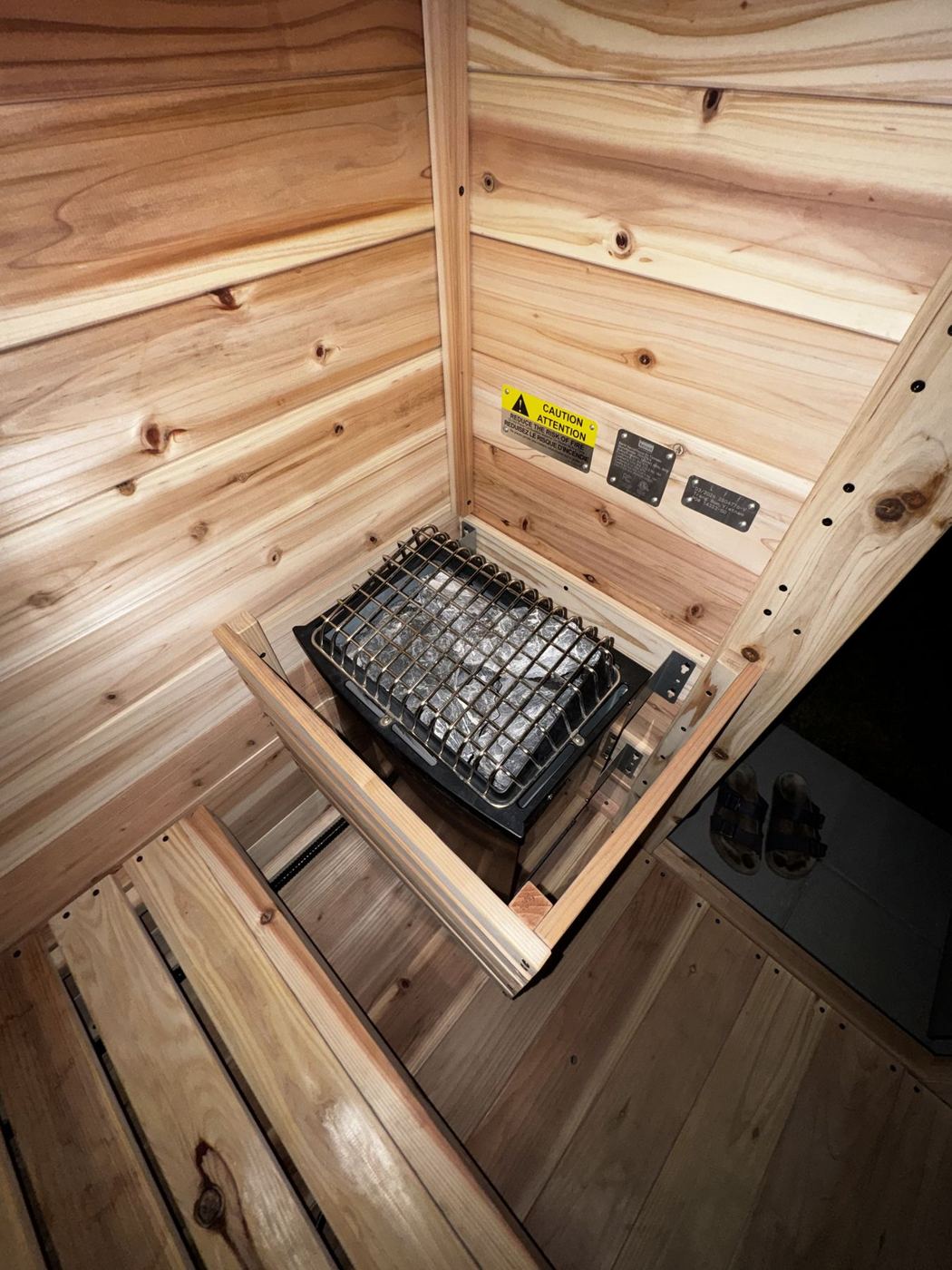 The heater and stones inside the cedar sauna